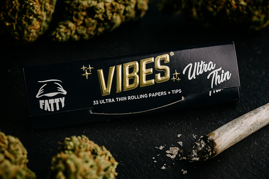 Vibes Ultra Thin rolling paper pack with buds and a rolled joint on a dark surface