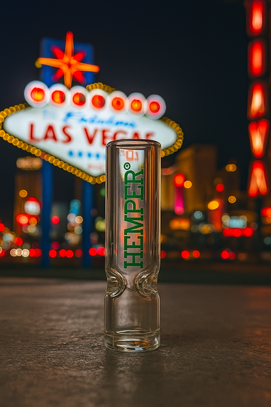 Glass pipe with 'Hemper' branding in front of the Las Vegas sign.
