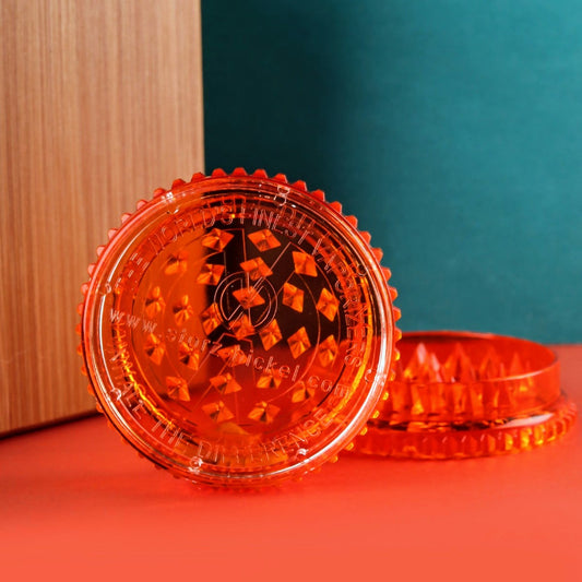 Orange grinder with brand logo on a red surface
